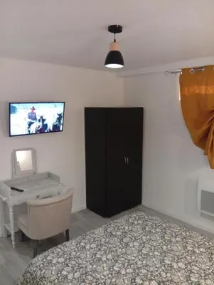 a bedroom with a bed and a desk and a television at Grand logement en souplex entier in Castres