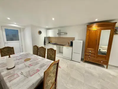 a dining room with a table and a kitchen at Grand logement en souplex entier in Castres