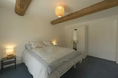 a bedroom with a bed and two lamps and a ceiling at La maison du merle bleu in Quintillan