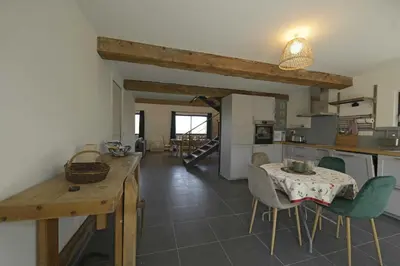 a kitchen and dining room with a table and chairs at La maison du merle bleu in Quintillan