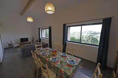 a dining room with a table and chairs and a window at La maison du merle bleu in Quintillan