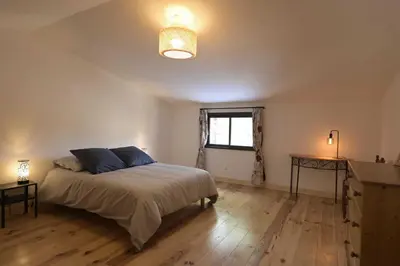 a bedroom with a large bed and a window at La maison du merle bleu in Quintillan
