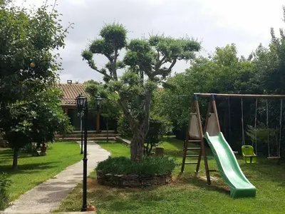 a playground with a slide and a swing at Holiday Home Charmante 3 Villa La Milouyette by Interhome in Peyriac-Minervois