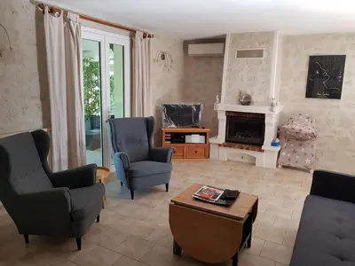 a living room with two chairs and a fireplace at Holiday Home Charmante 3 Villa La Milouyette by Interhome in Peyriac-Minervois
