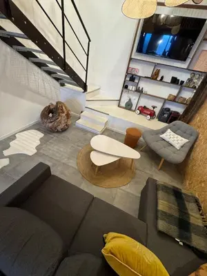a living room with a couch and a chair at Un duplex pas comme les autres in Carcassonne