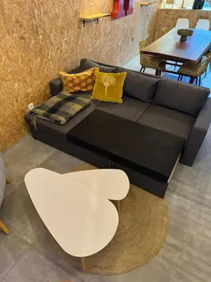 a black couch with yellow pillows and a table at Un duplex pas comme les autres in Carcassonne