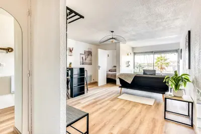 a bedroom with a bed and a living room at Studio cosy au bord du port à proximité de tout commerce in Gruissan