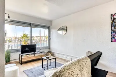 a living room with a couch and a tv at Studio cosy au bord du port à proximité de tout commerce in Gruissan