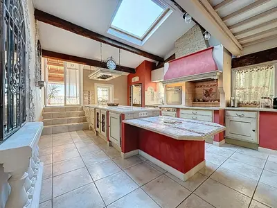 a large kitchen with red and white cabinets and a skylight at Le Mirabeau - Appartement bourgeois - Terrasse 80m2 - Wifi et Climatisation in Narbonne
