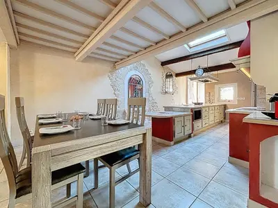 a large kitchen with a wooden table and chairs at Le Mirabeau - Appartement bourgeois - Terrasse 80m2 - Wifi et Climatisation in Narbonne