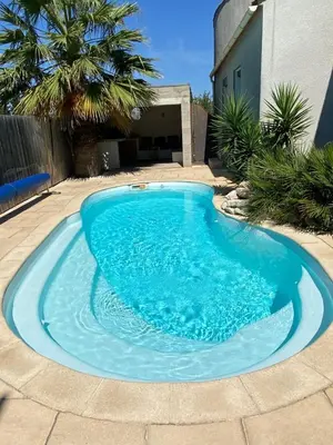 a large blue swimming pool in a yard at L'Échappée Belle 3 étoiles - Piscine, Jardin et Pool-house - Proche Cité in Carcassonne