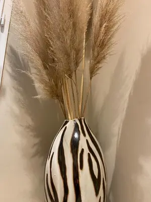 a black and white vase with feathers in it at L'Échappée Belle 3 étoiles - Piscine, Jardin et Pool-house - Proche Cité in Carcassonne