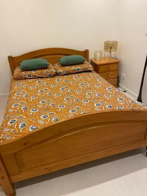 a bed with a wooden frame and pillows on it at L'Échappée Belle 3 étoiles - Piscine, Jardin et Pool-house - Proche Cité in Carcassonne