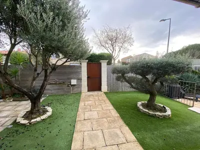 a garden with two trees and a wooden door at L'Échappée Belle 3 étoiles - Piscine, Jardin et Pool-house - Proche Cité in Carcassonne
