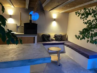 a room with a bench and a table and a stool at L'Échappée Belle 3 étoiles - Piscine, Jardin et Pool-house - Proche Cité in Carcassonne