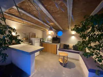 a kitchen with a counter and a stool in a room at L'Échappée Belle 3 étoiles - Piscine, Jardin et Pool-house - Proche Cité in Carcassonne