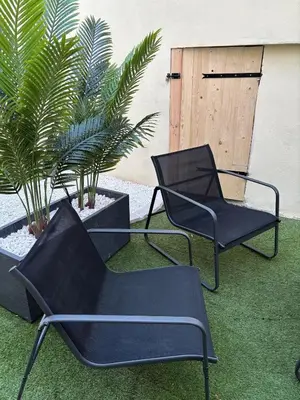 two black chairs and plants in a yard at Suite Bali et sauna privé - vidéo projecteur - escapade romantique-centre in Carcassonne