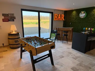 a foosball table in a room with a bar at Gîte La Choule in Mourvilles-Hautes