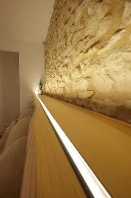 a bedroom with a wall with a stone wall at Gîte La Choule in Mourvilles-Hautes