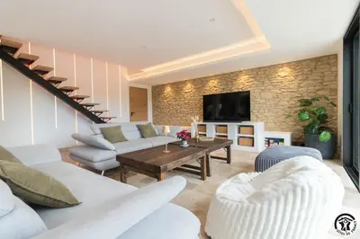 a living room with white furniture and a tv at Gîte La Choule in Mourvilles-Hautes