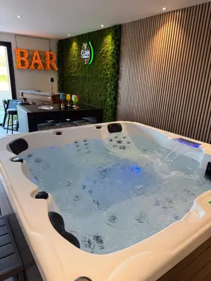 a large bath tub in a room with a bar at Gîte La Choule in Mourvilles-Hautes