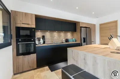 a kitchen with black and wooden cabinets and a counter at Gîte La Choule in Mourvilles-Hautes