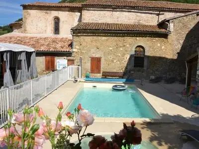 a pool in front of a building with a house at Camping 3 étoiles - Piscine - ccbecba in Roquefeuil