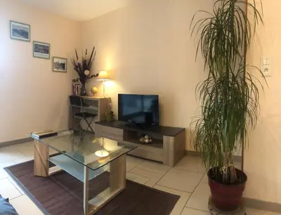 a living room with a tv and a glass table at Gîte Au Coeur Du Pays Cathare in Fanjeaux