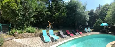 a group of lounge chairs next to a swimming pool at Gîte Au Coeur Du Pays Cathare in Fanjeaux