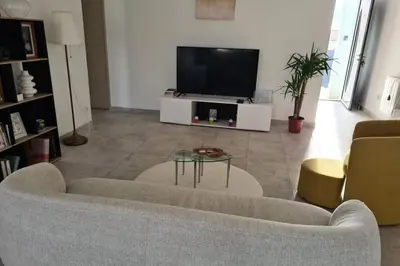 a living room with a couch and a tv at Bright house in Pezens for 8 people in Pezens