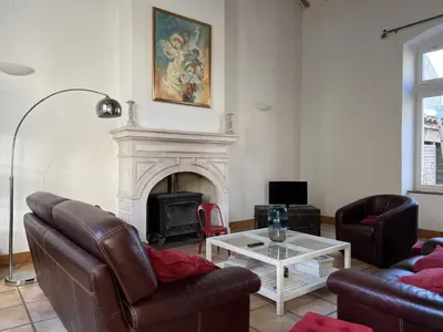 a living room with a couch and a fireplace at Bienvenue à l'école des garçons ! in Ouveillan