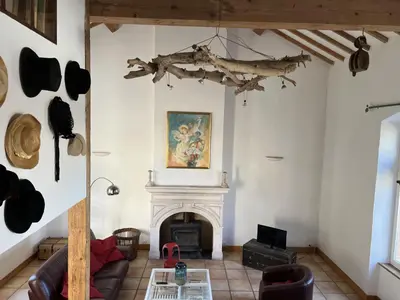 a living room with a fireplace and a couch at Bienvenue à l'école des garçons ! in Ouveillan