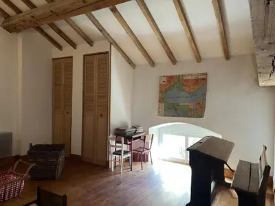 a living room with a table and a piano at Bienvenue à l'école des garçons ! in Ouveillan