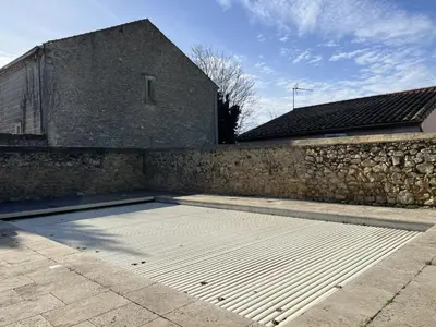 an empty garage in front of a stone wall at Bienvenue à l'école des garçons ! in Ouveillan