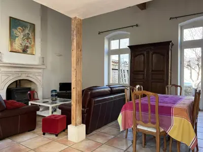 a living room with a table and a couch at Bienvenue à l'école des garçons ! in Ouveillan