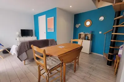 a living room with a wooden table and a couch at Lo Cabanot maison de pêcheur pour 4 in Port-la-Nouvelle