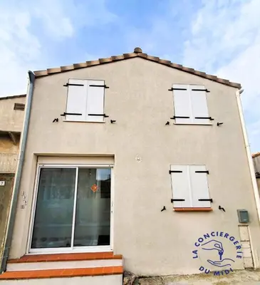 a building with white doors on the side of it at Lo Cabanot maison de pêcheur pour 4 in Port-la-Nouvelle