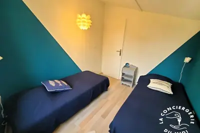 two beds in a room with green walls at Lo Cabanot maison de pêcheur pour 4 in Port-la-Nouvelle