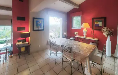 a dining room with red walls and a table and chairs at Un Veritable Havre De Paix in Roquebrun