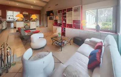 a living room with a white couch and a kitchen at Un Veritable Havre De Paix in Roquebrun