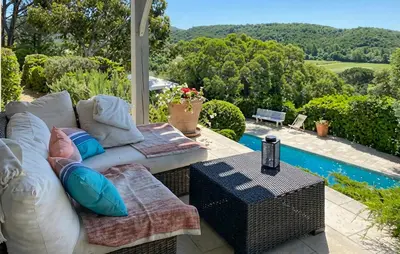 a patio with a couch and a table next to a pool at Un Veritable Havre De Paix in Roquebrun