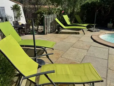 a group of green chairs sitting next to a pool at La Rocaille, house for 6 with swimming pool in Roquebrun