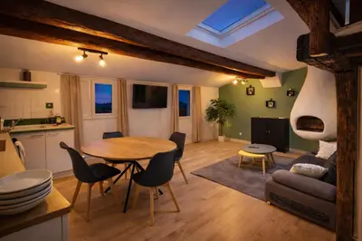 a living room with a table and chairs and a television at Studio scandinave près de la Cathédrale - Narbonne in Narbonne