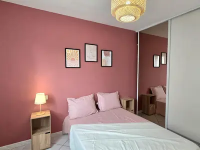 a bedroom with a bed and a pink wall at Grande maison familiale, spacieuse et confortable in Espira-de-lʼAgly
