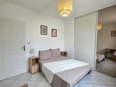 a white bedroom with a bed and a mirror at Grande maison familiale, spacieuse et confortable in Espira-de-lʼAgly
