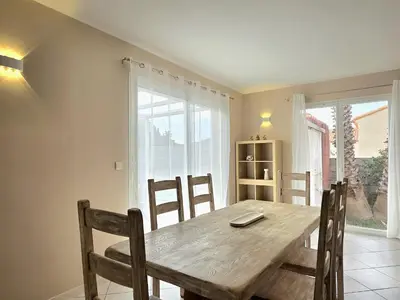a dining room with a wooden table and chairs at Grande maison familiale, spacieuse et confortable in Espira-de-lʼAgly