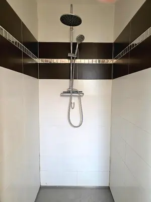 a shower in a bathroom with black and white tiles at Grande maison familiale, spacieuse et confortable in Espira-de-lʼAgly
