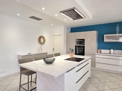 a kitchen with a white island in a room at Grande maison familiale, spacieuse et confortable in Espira-de-lʼAgly