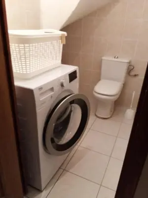 a bathroom with a washing machine and a toilet at La Sigeannaise belle maison près des plages in Sigean