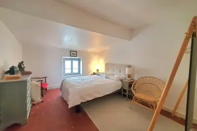 a bedroom with a bed and a desk and a window at La Sigeannaise belle maison près des plages in Sigean